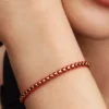 Armband mit Snake Chain und rotem Textilschnurband, 14-karätig vergoldet Armband mit Snake Chain und rotem Textilschnurband, 14-karätig vergoldet