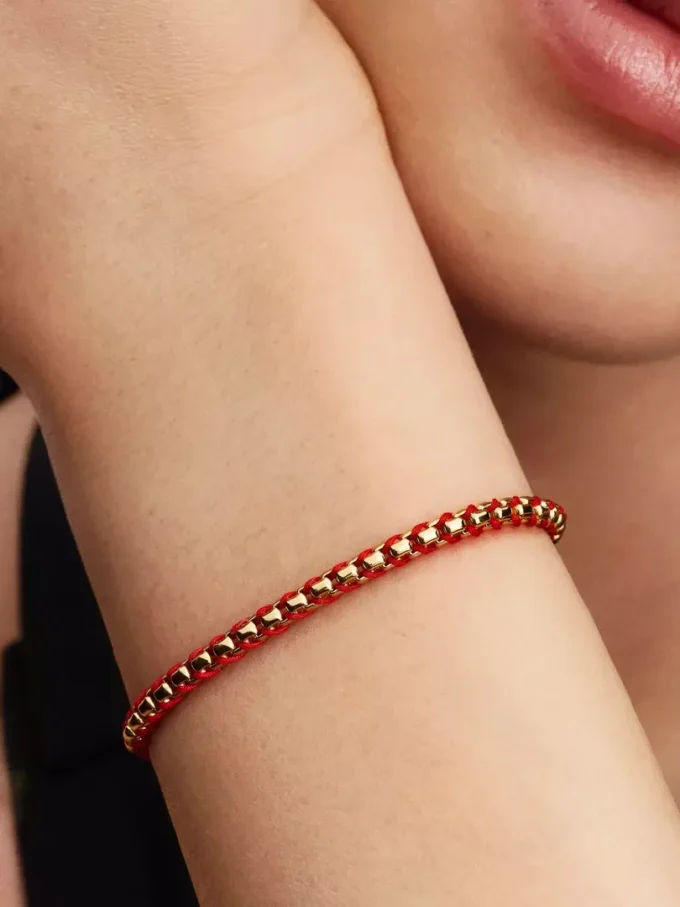 Armband mit Snake Chain und rotem Textilschnurband, 14-karätig vergoldet Armband mit Snake Chain und rotem Textilschnurband, 14-karätig vergoldet